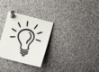 Post-it note on a pin board with a lightbulb drawing
